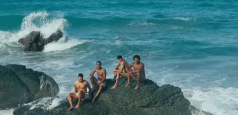 Amigos sobre las rocas frente al mar