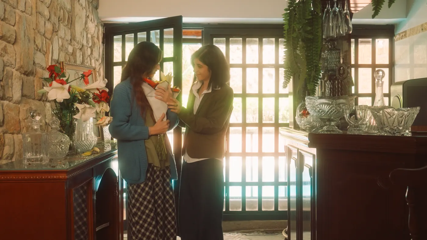 Dos mujeres conversando junto a una ventana